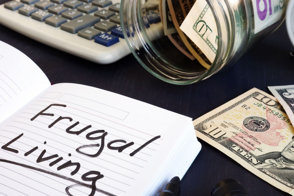 Photo of money and notebook with frugal living wording.