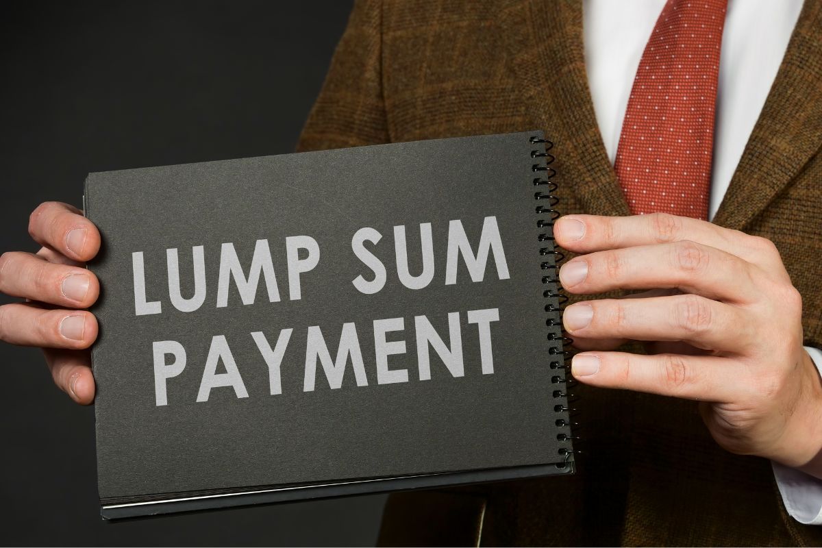 A man's hand holding a notebook with lump sum payment wording.