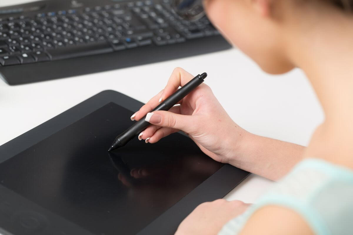 The picture shows a keyboard and a girl using a digital sketcher to monetize a hobby quickly and turn it into cash to put extra money toward debt.