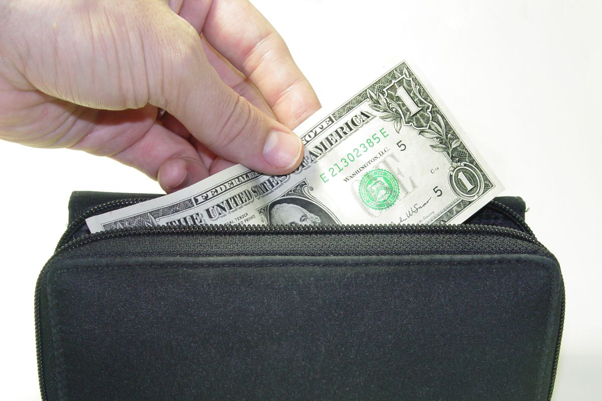 Photo of a woman's hand saving money on her wallet.