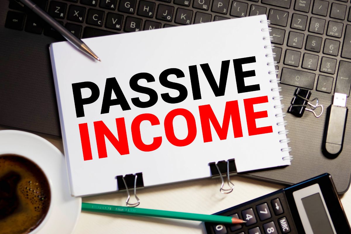 The photo shows a notebook with passive income wording.