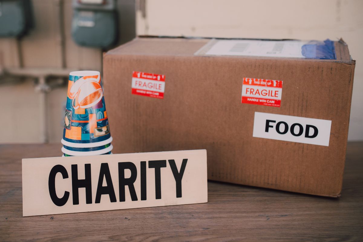 The image shows cups, a box with notes, and a piece of paper with a a note referring to contribute to a charitable to give back from blessing.