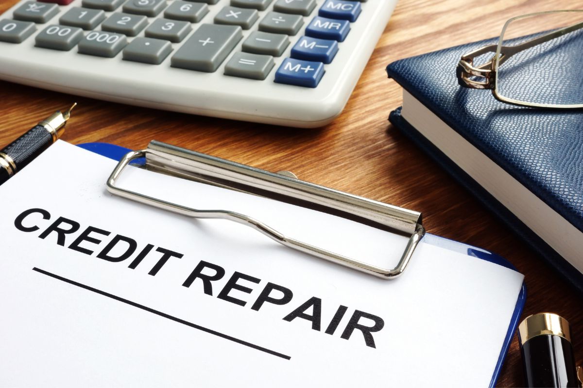 The photo of a calculator, a notebook, a pen, an eyeglass, and a clipboard with notes, which means to gamify your credit repair, can help you stay motivated and boost your credit score.