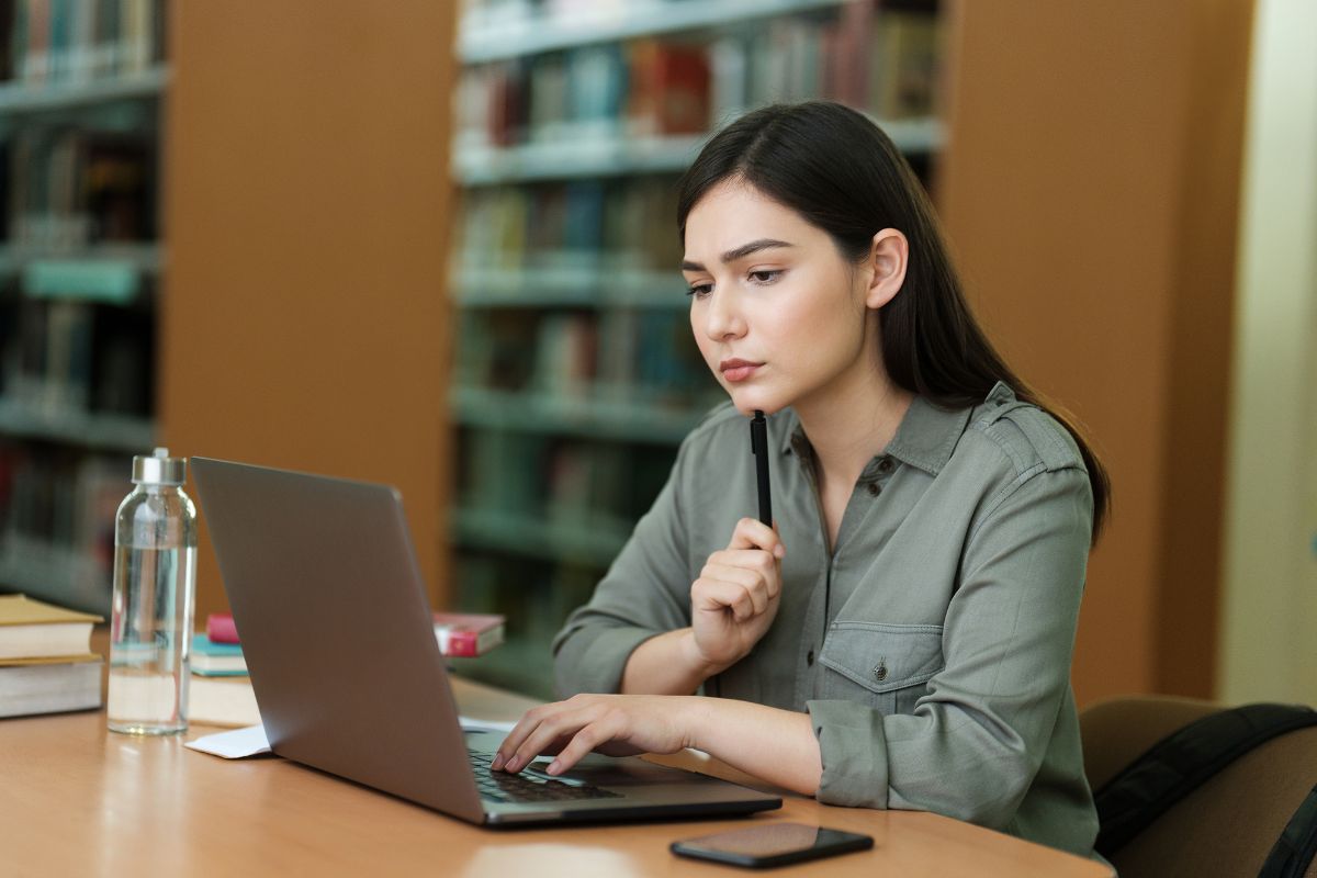 The image shows a girl using a laptop indicating that understanding taxable vs. non-taxable income can help you avoid surprises as taxable income.