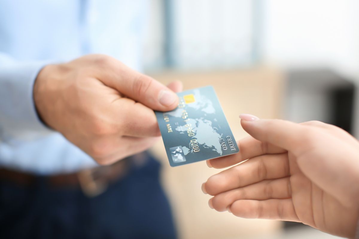 Image of a man's hand authorizing his credit card to a girl.
