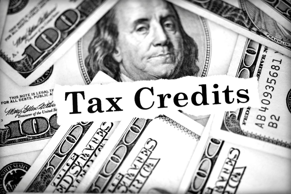 The photo shows dollar bills and a piece of paper with notes which means to take advantage of education tax credits can lower the amount you owe or increase your refund.