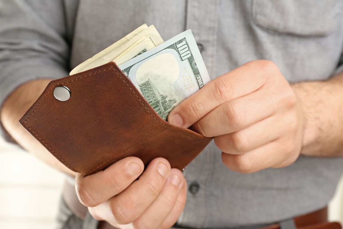 The image shows a man setting aside money.