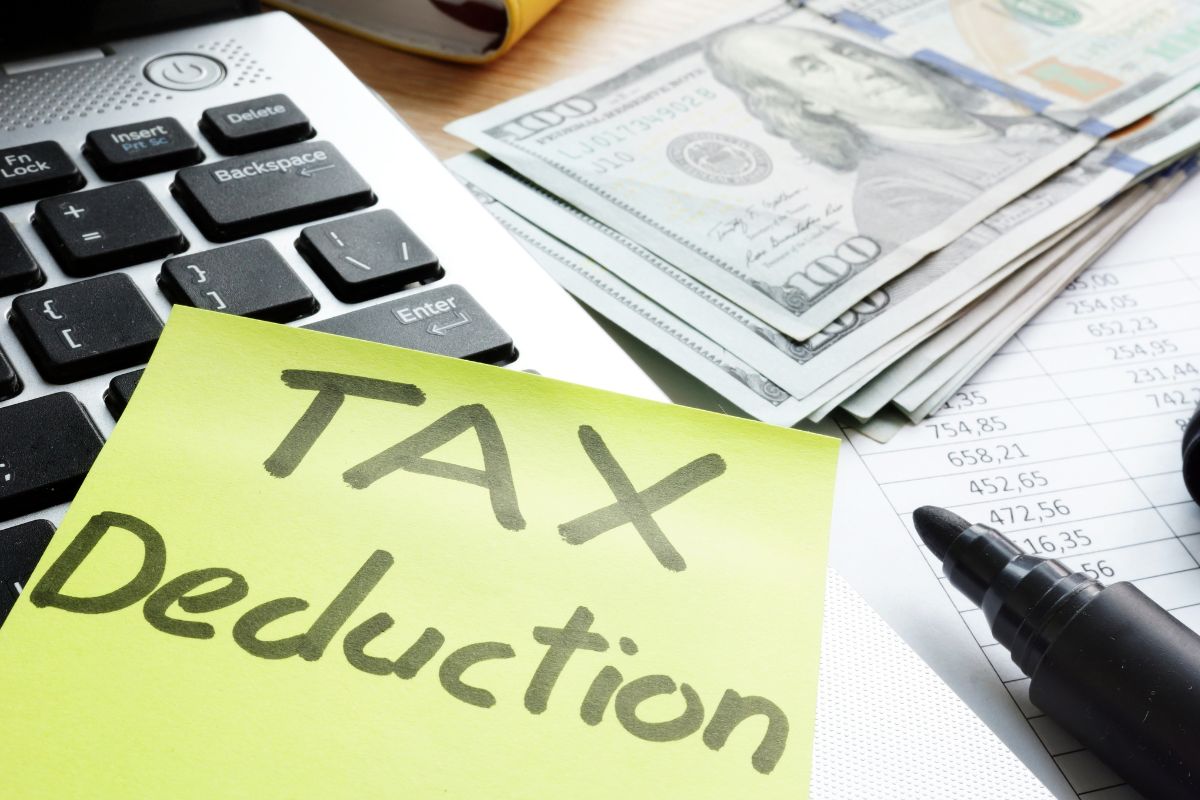 Image of money and paper with tax deduction written.