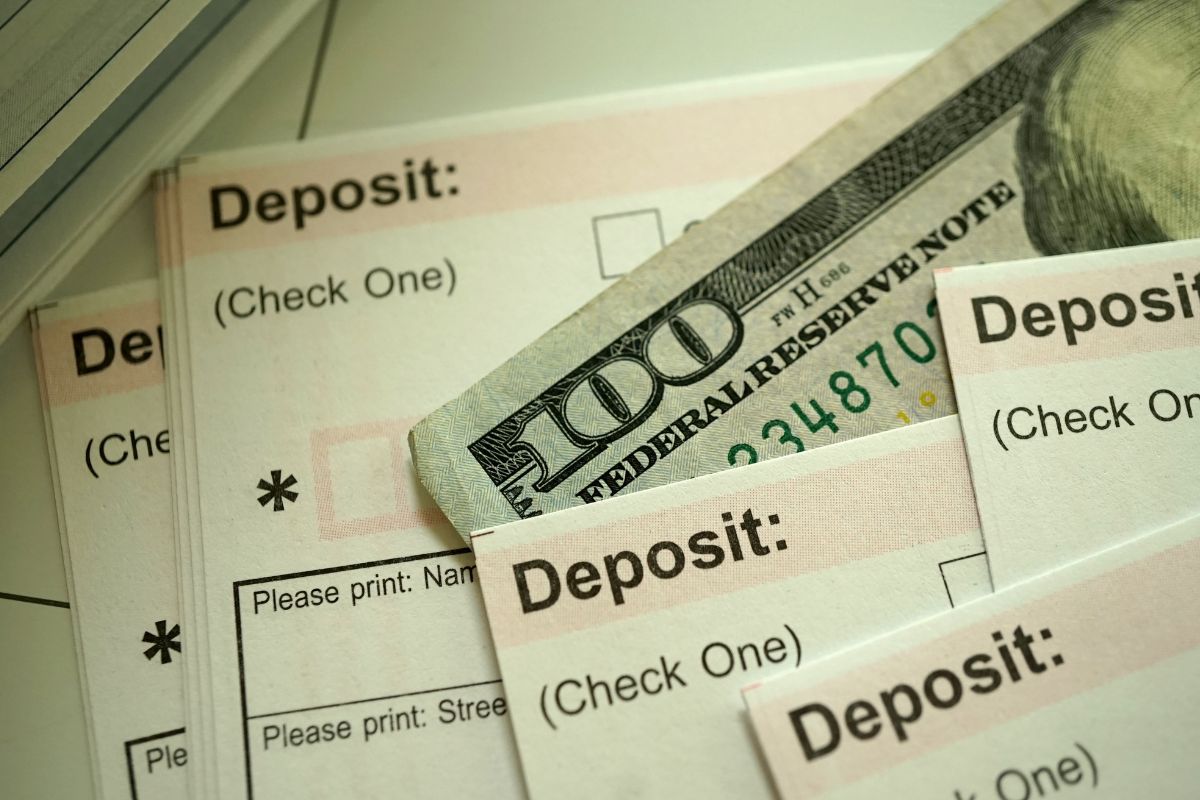 The photo shows papers with notes and a one hundred dollar bill referring to direct deposit of your refund for faster processing and the quickest way to get a tax refund.