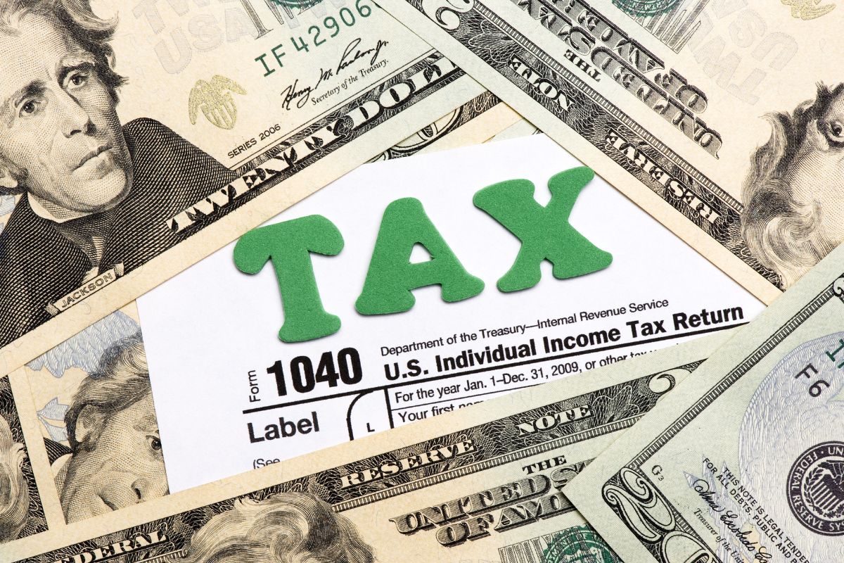 The photo shows dollar bills and a piece of paper with notes and letters referring to why you owe taxes this year, understanding why helps you plan better for next year.