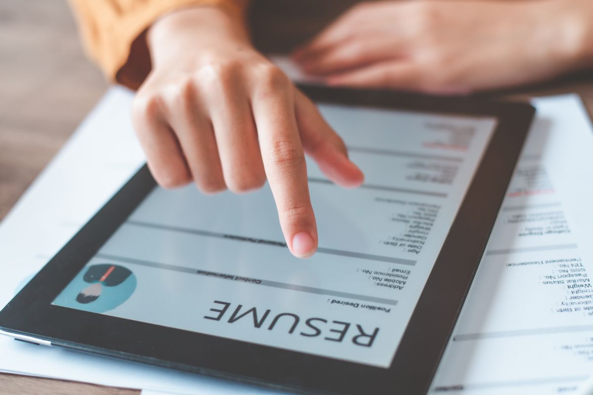 The photo photo shows a woman's hand using an AI resume builders.