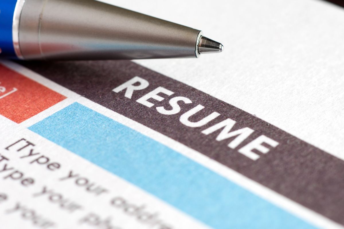 The image of a pen and resume.