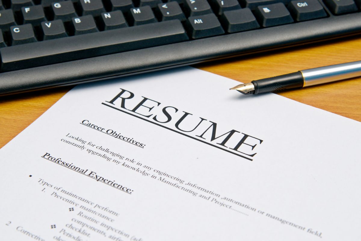 The photo shows a keyboard and a resume.