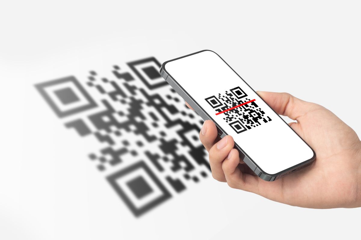 The photo shows a man's hands scanning a QR code.