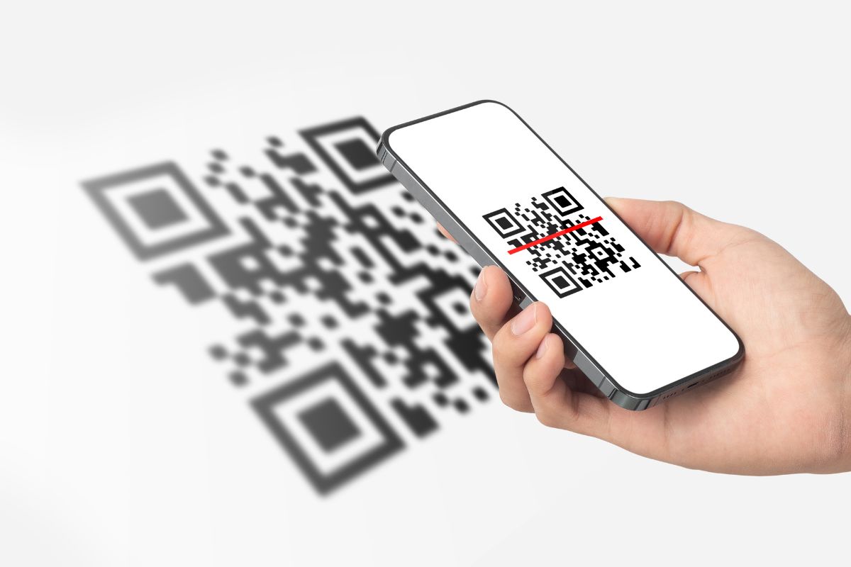 The photo tells about a man's hand using a phone to take a picture which refers to adding a QR code linking to your portfolio makes it easy for hiring managers to see more of your work.