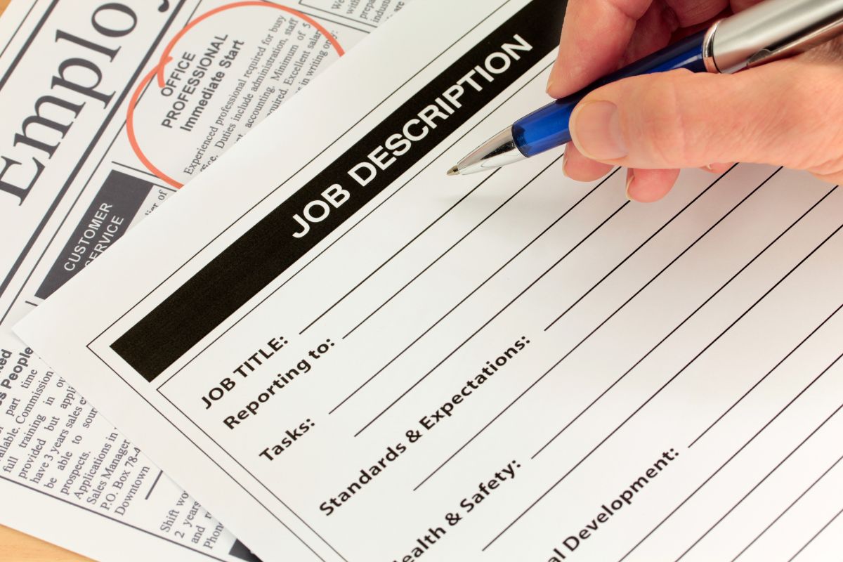 The picture of a newspaper and a man's hand and writing on the paper refer to turning job descriptions into mini case studies by explaining how your work made a difference that shows impact stands out more.