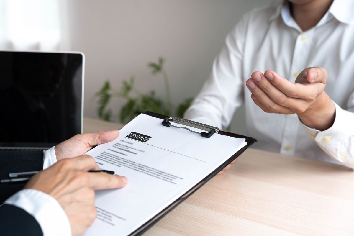 The picture shows a suit pointing to the resume and an applicant explaining referring to creating a separate skills in the action section makes your resume more convincing. 