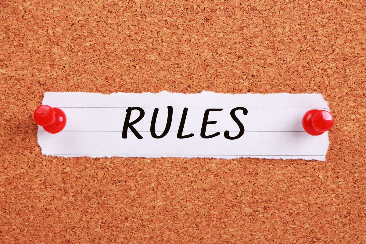 The image shows a piece of paper with a note and pin on the board indicating that following the 50/30/20 rule loosely helps adjust and track expenses.