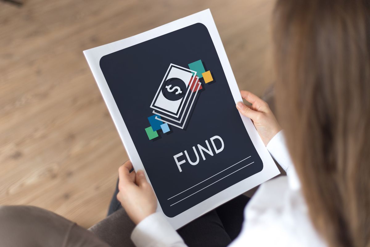 The photo shows a girl's hand holding a piece of paper with a note and money drawing referring to the use of the fun fund method by setting aside money for guilt-free spending.