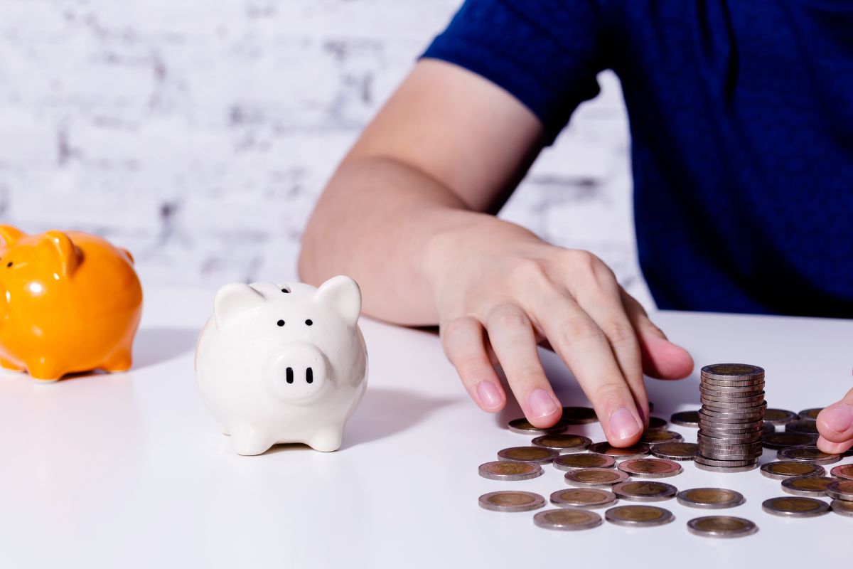 The image tells about piggy banks and a man filing and counting coins which means to try the 1% fun rule to put the 1% of your income for fun and avoid breaking your bank.