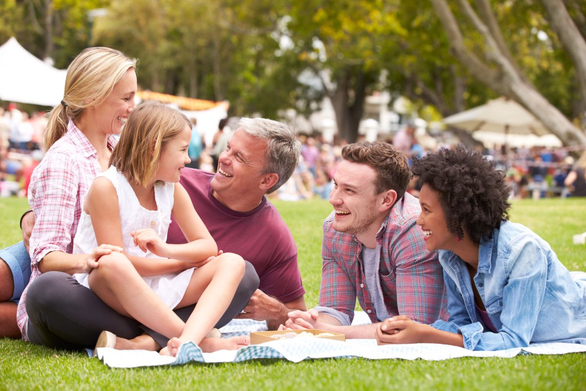 The picture shows a group of family  having a bonding together at the park which means set experience over stuff goals to save money and create a long lasting memories to cherish.
