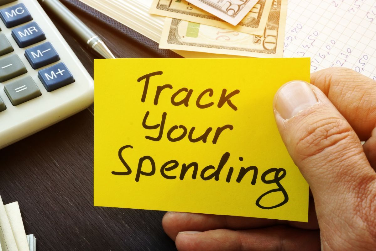 A foto mostra a mão de um homem monitorando seus gastos divertidos.