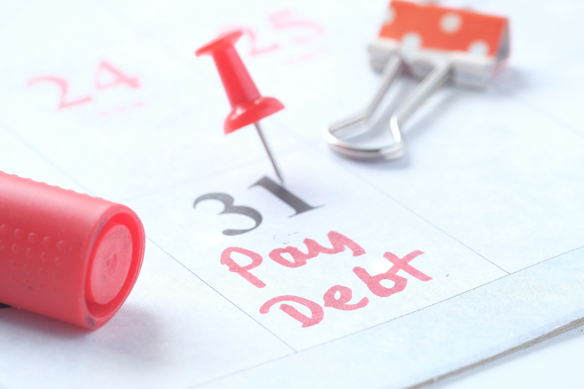 The image shows a calendar with a pay debt note.