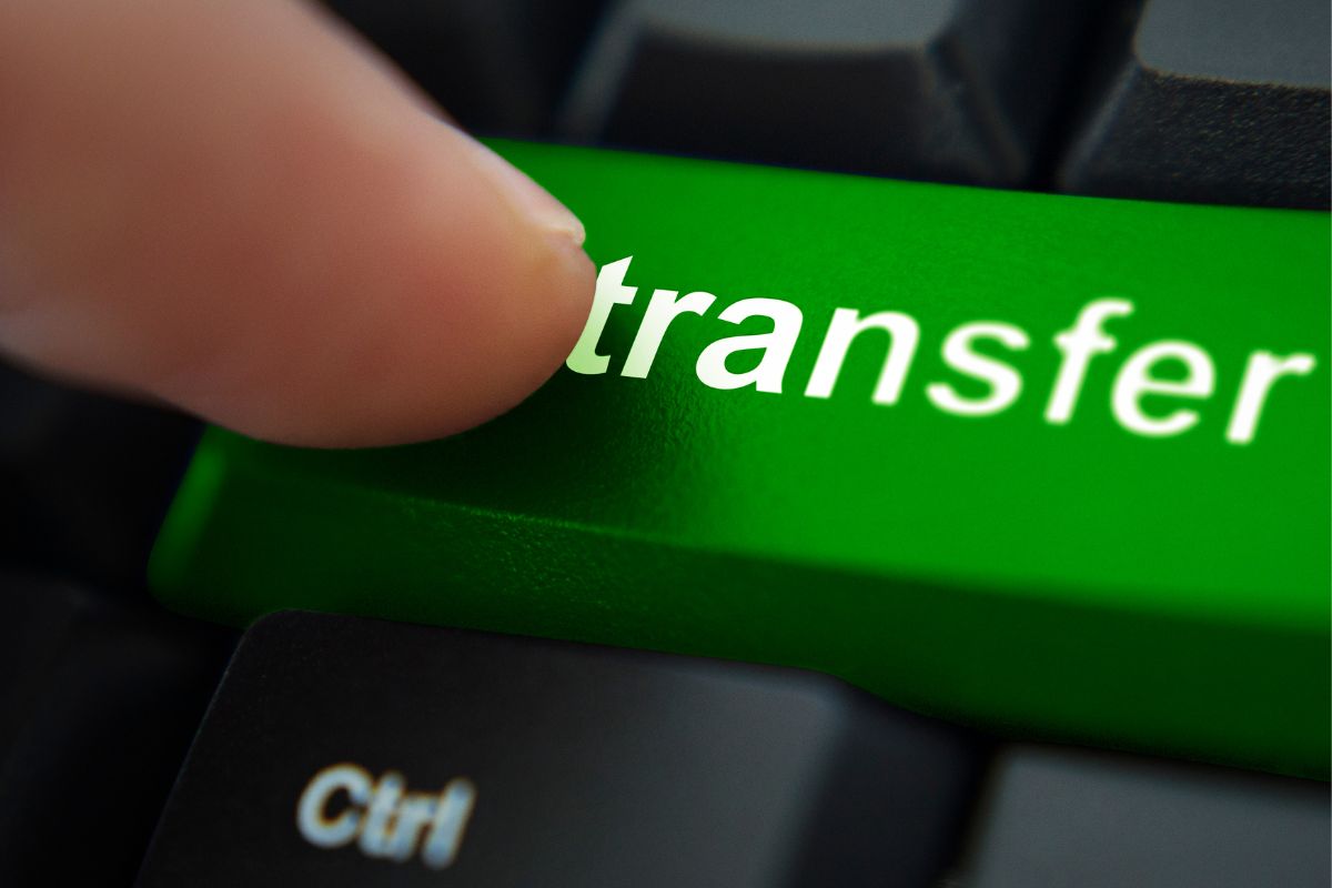 The photo of a woman's hand tapping the transfer button.