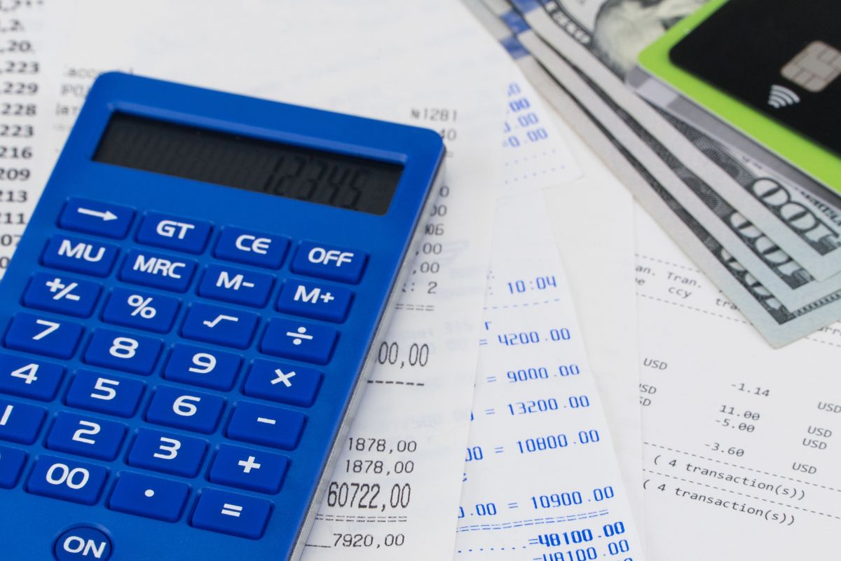 Image of a calculator, money, and credit cards, as well as receipts.