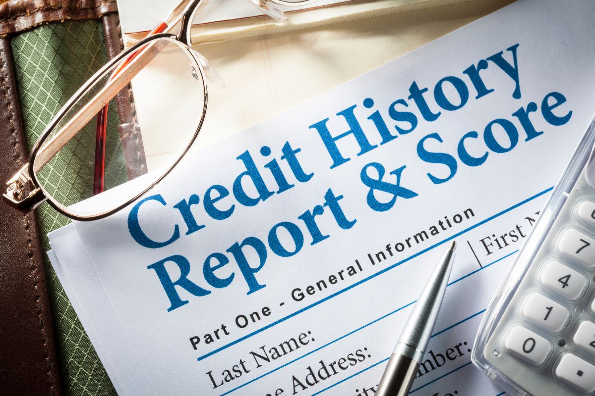 The image shows an eyeglass, a pen, a calculator, and papers with notes indicating old or incorrect negative items on your credit report, which is an easy way to improve your credit score.