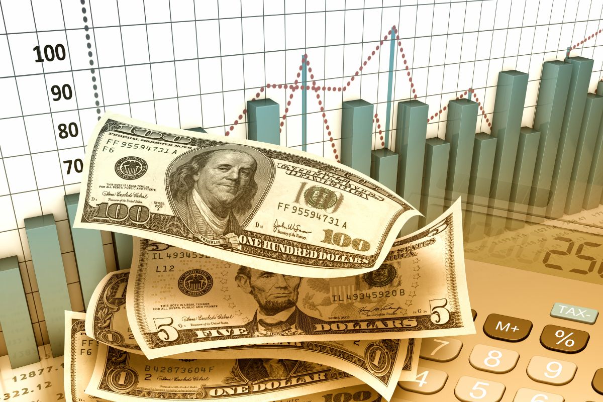 The picture shows a graph, a calculator, and dollar bills which means automating wealth-building by setting up recurring investments makes sure you're always growing your money without thinking about it and wealth builds without effort.