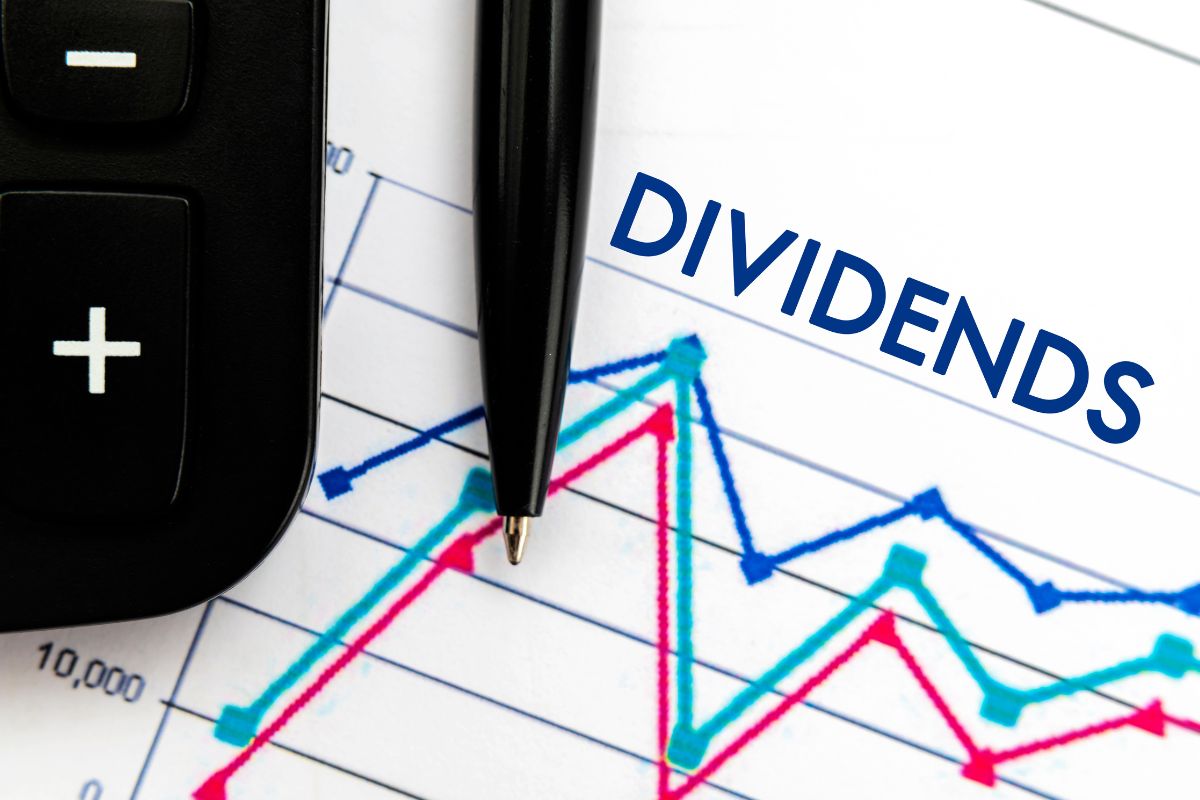 The photo shows a calculator and a piece of paper with dividends wording.