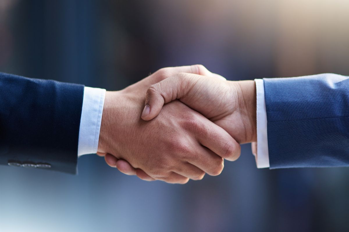 The picture shows men's hands shaking.