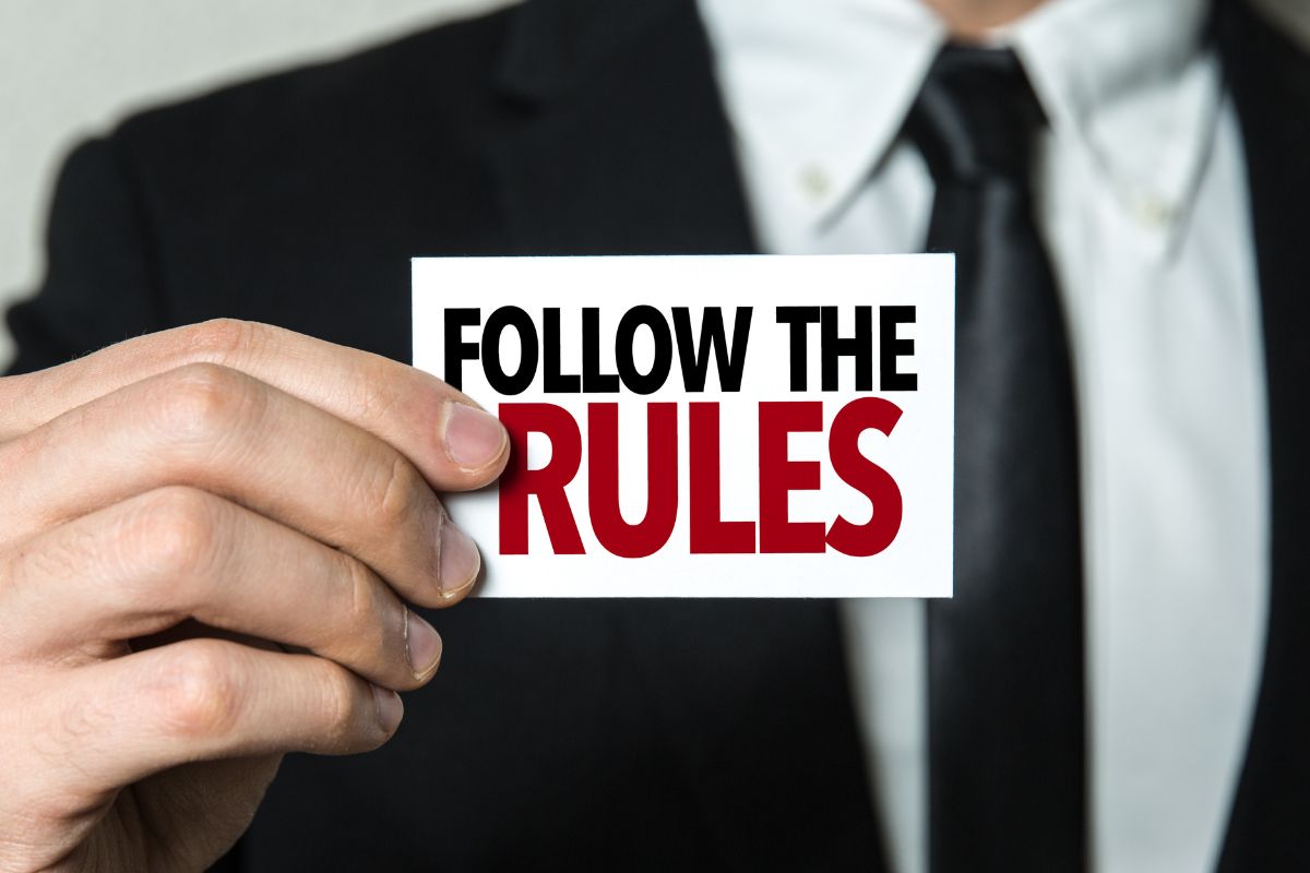 The image shows a man's hand holding a piece of paper with notes referring to following the 100x rule can grow a hundred times bigger than its starting point.