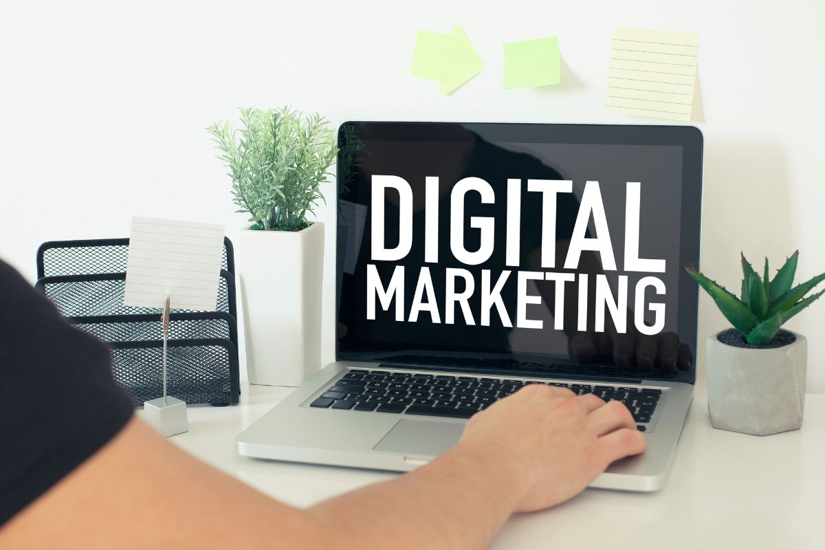 An image shows a man's hand working on digital marketing.