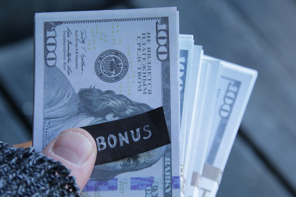 Picture of a woman's hand holding money bonus.