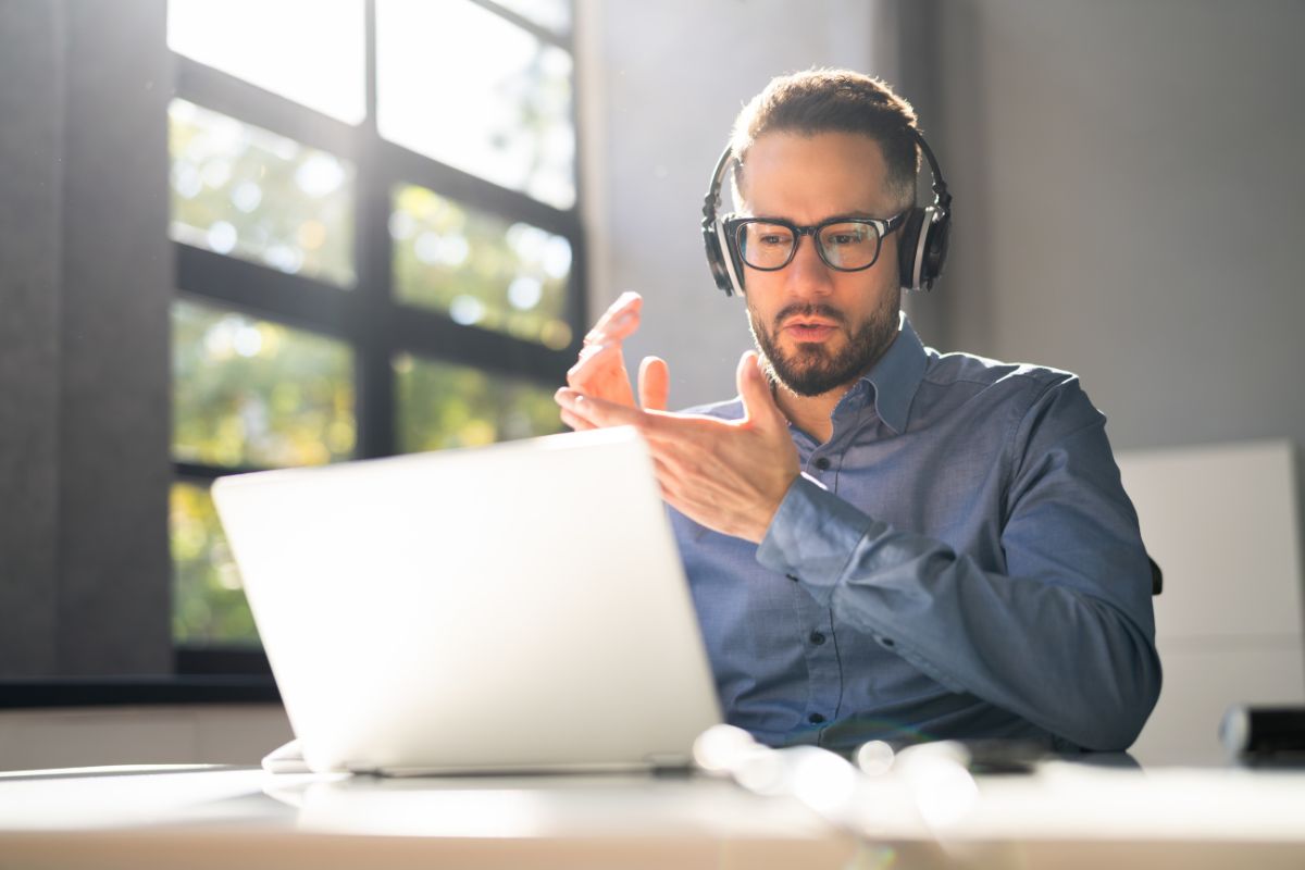 The picture tells about a man using a laptop while listening thru headphones which means an online mock juror is one of the easiest side jobs that fit your schedule.