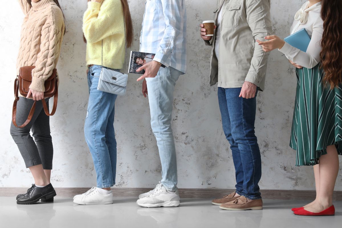 The picture shows a group of people falling in line referring to professional lien sitters is an easy way to make money without a set schedule. 