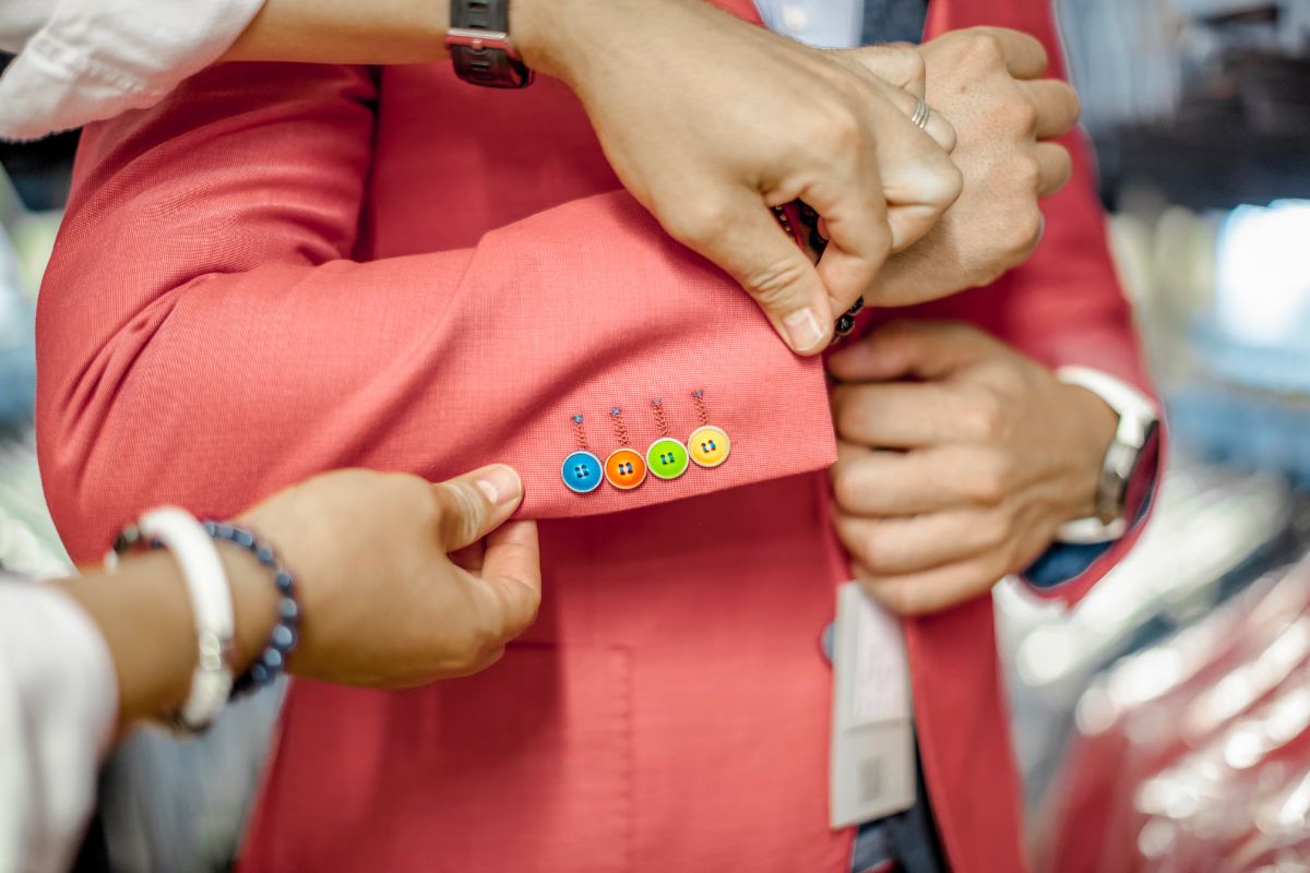 The picture shows a girl's hand fixing the clothes of a man referring to becoming a personal stylist making it a flexible way to earn money. 
