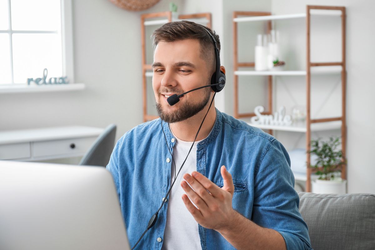 The photo shows a man working as an online chat agent.