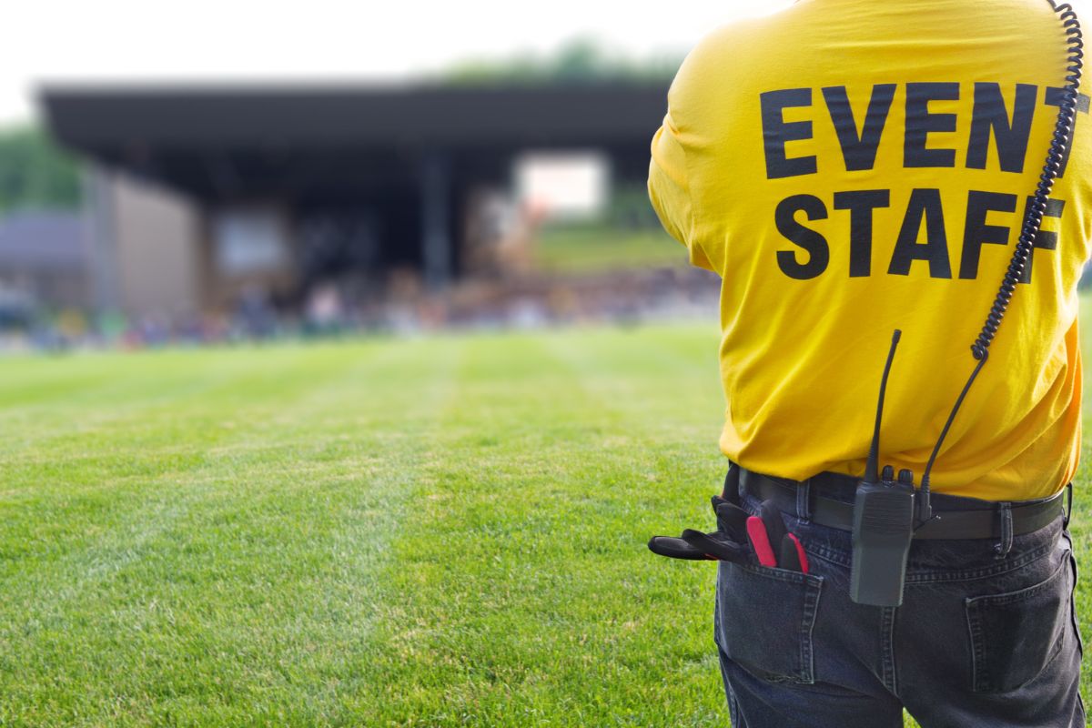 The image tells about a man standing at the open field which means an event staff making them great for extra cash without long-term commitment that fits your schedule.