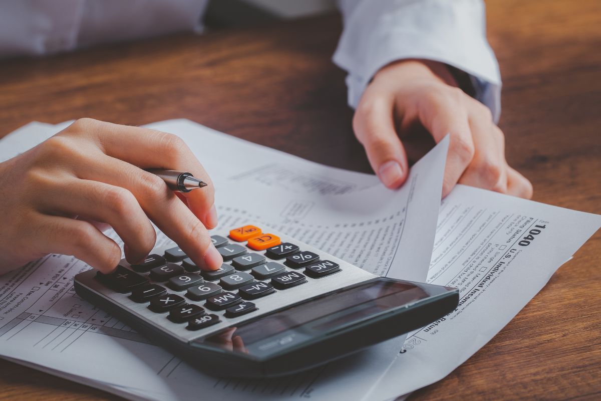 The picture shows a woman calculating her taxes.
