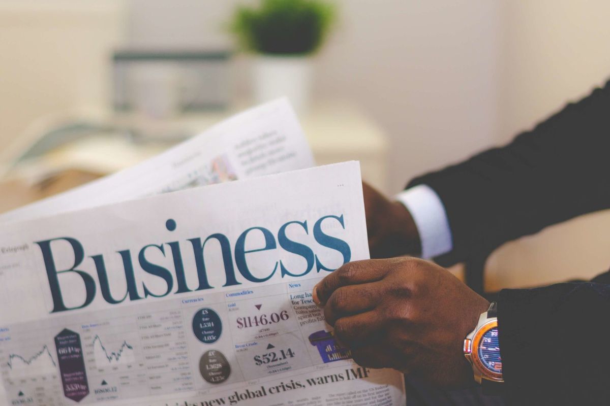 The photo tells about a man's hand holding a paper with notes referring to how ignoring business expense deductions could mean a bigger tax bill, taking time to record and saving a lot of money.