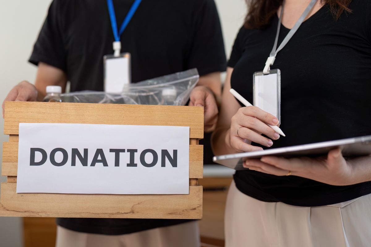 The image shows a girl holding a tablet device while checking the items on the box with a note referring to failing to track charitable donations could lose out on a deduction, and documenting them could mean paying less in taxes.
