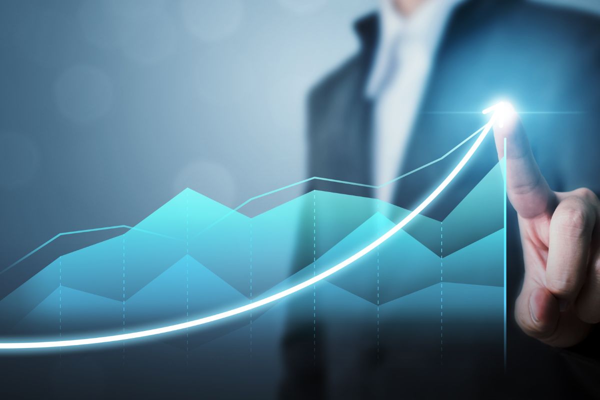 The picture shows a man's hand showing a sales graph.