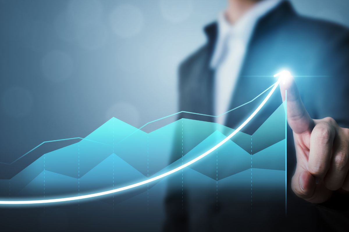 The picture shows a man pointing to the graph referring to sales and business development helping to grow wealth by driving revenue through strategic partnership and lead generation and growing a company.