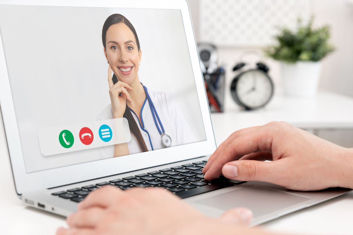 The photo shows a woman's hand working on a telemedicine.