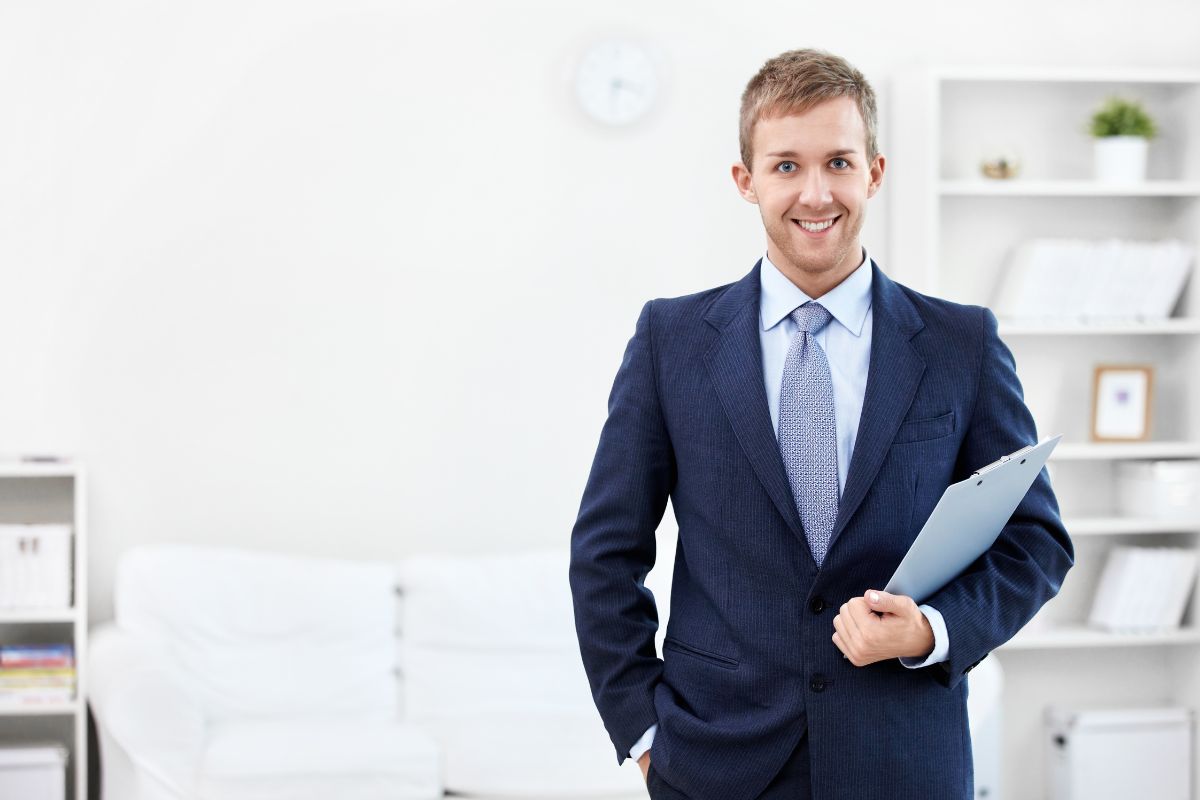 The photo shows a man in a suit holding a clipboard which means financial consulting helps people to manage their finances with guides, is one of the in-demand skills and helping people on their right path.