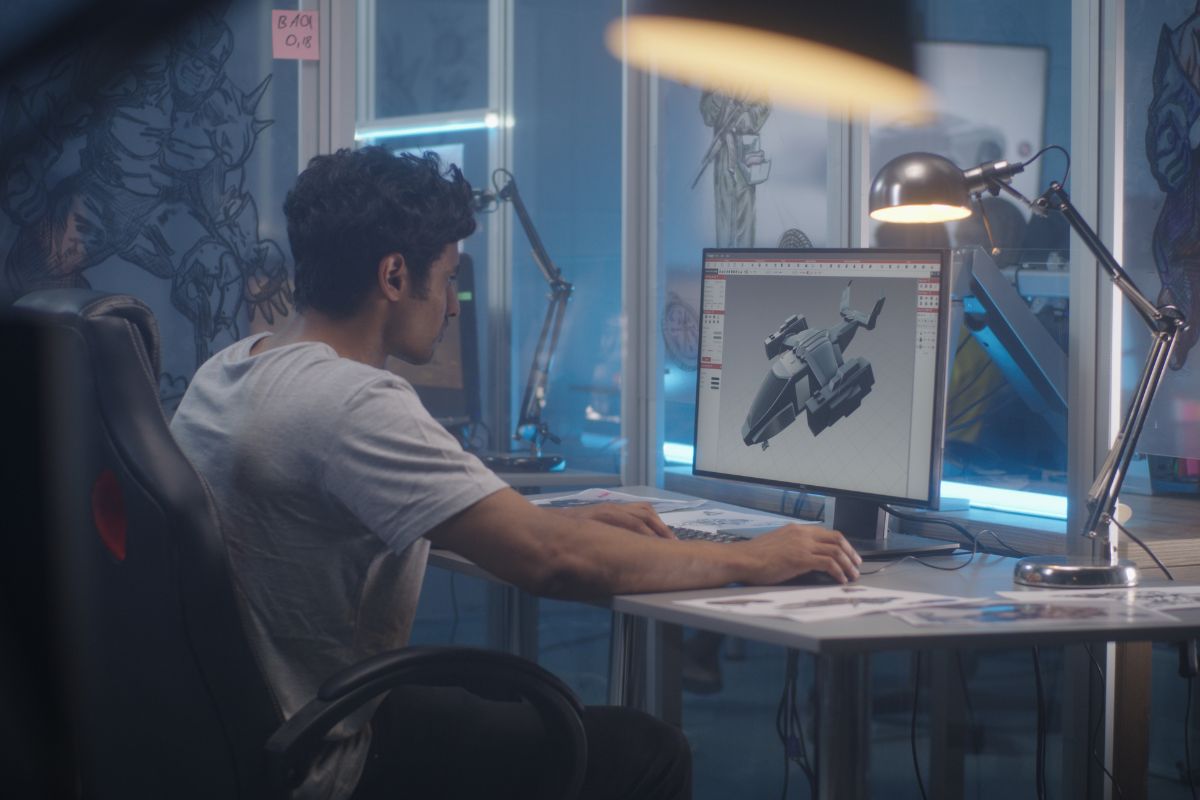 The picture shows a man working on 3D modeling on a computer.