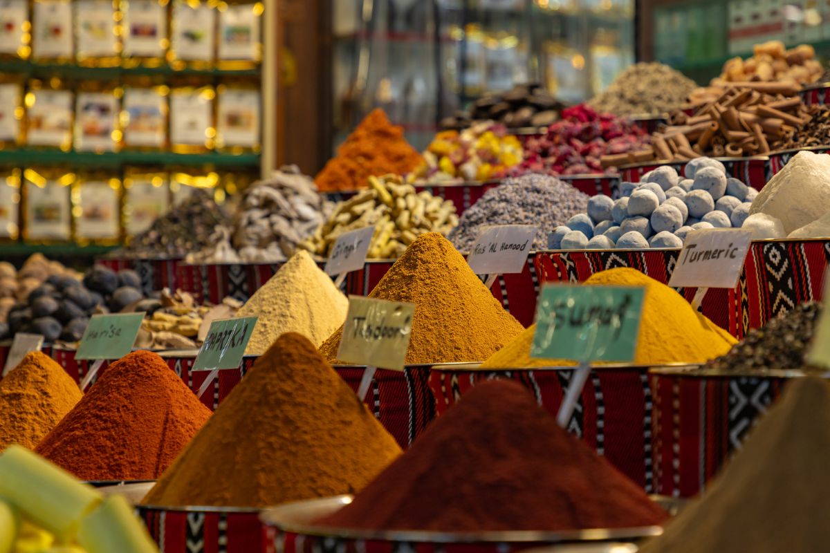 The picture shows different types of spices in a store which refers to shop at ethnic grocery stores that can cost less and a great way to cut grocery cost without sacrificing variety.